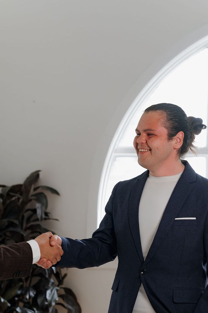 Ernie, founder of Kisâkihitin Human Resource Group, shaking hands with a client during a professional meeting.